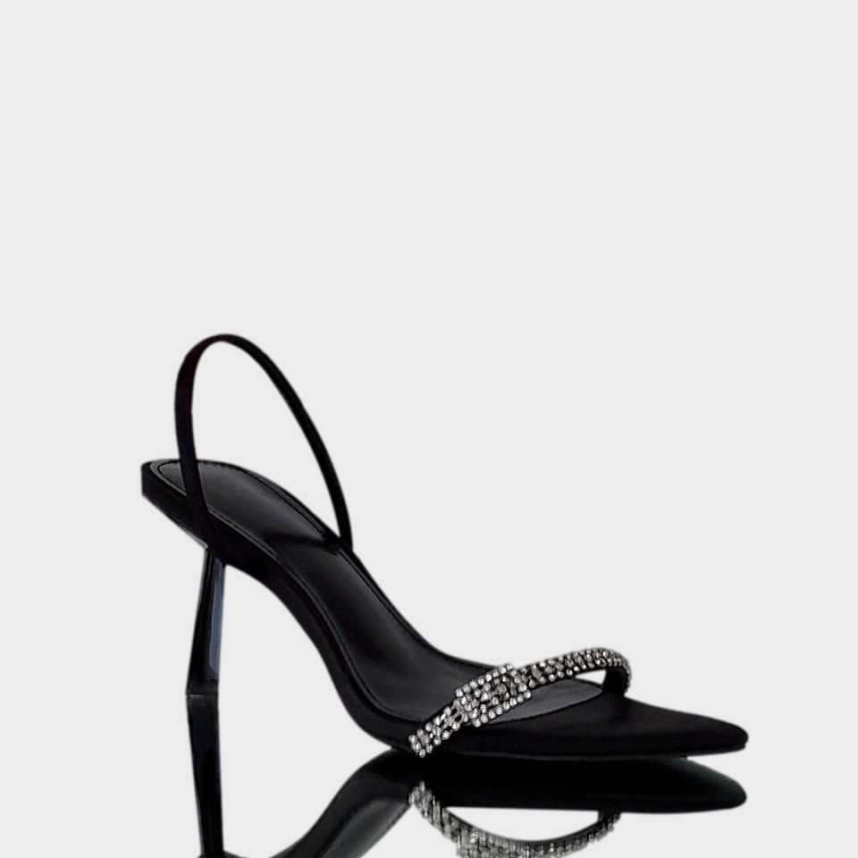Vista lateral de las sandalias Carol Black, en raso negro, con tira de strass sobre los dedos y taco geométrico de 8 cm en acrílico al tono