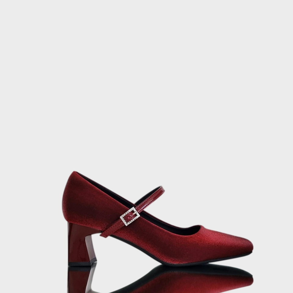 Vista lateral de Zapatos Emma Bordeaux, de estilo francés, en materail satinado bordeaux, con taco bloque de acrílico al tono de 5 cm, y correa de charol que se ajusta  al empeine con una delicada hebilla de strass