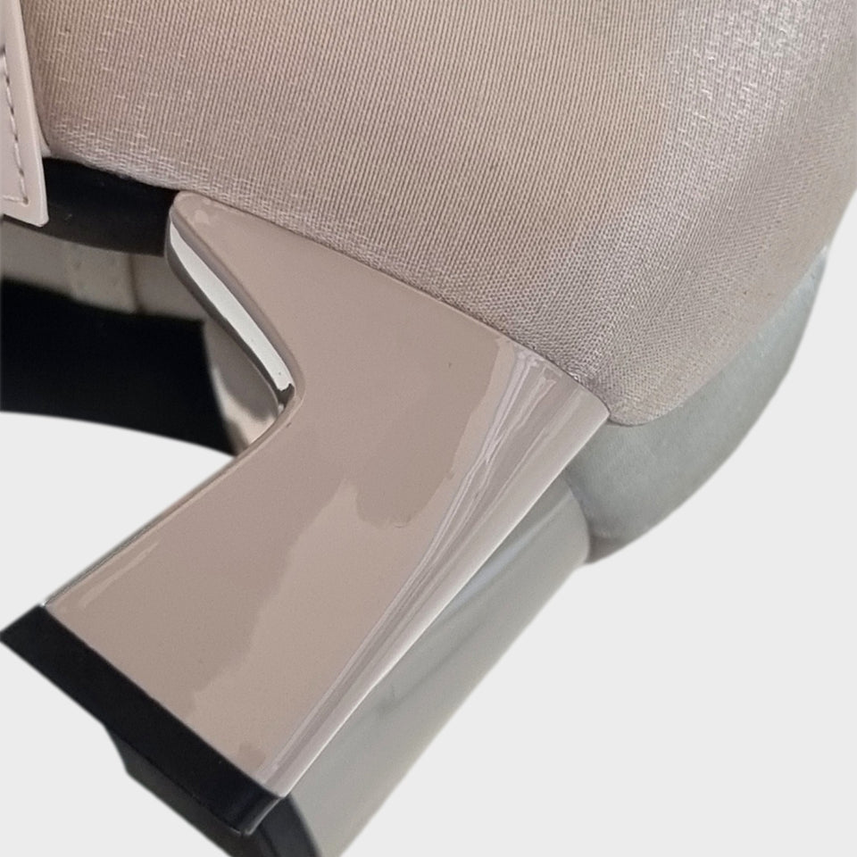 Vista en detalle del taco de los Zapatos Emma Champagne, de estilo francés, en materail satinado natural, con taco bloque de acrílico al tono de 5 cm, y correa de charol que se ajusta  al empeine con una delicada hebilla de strass