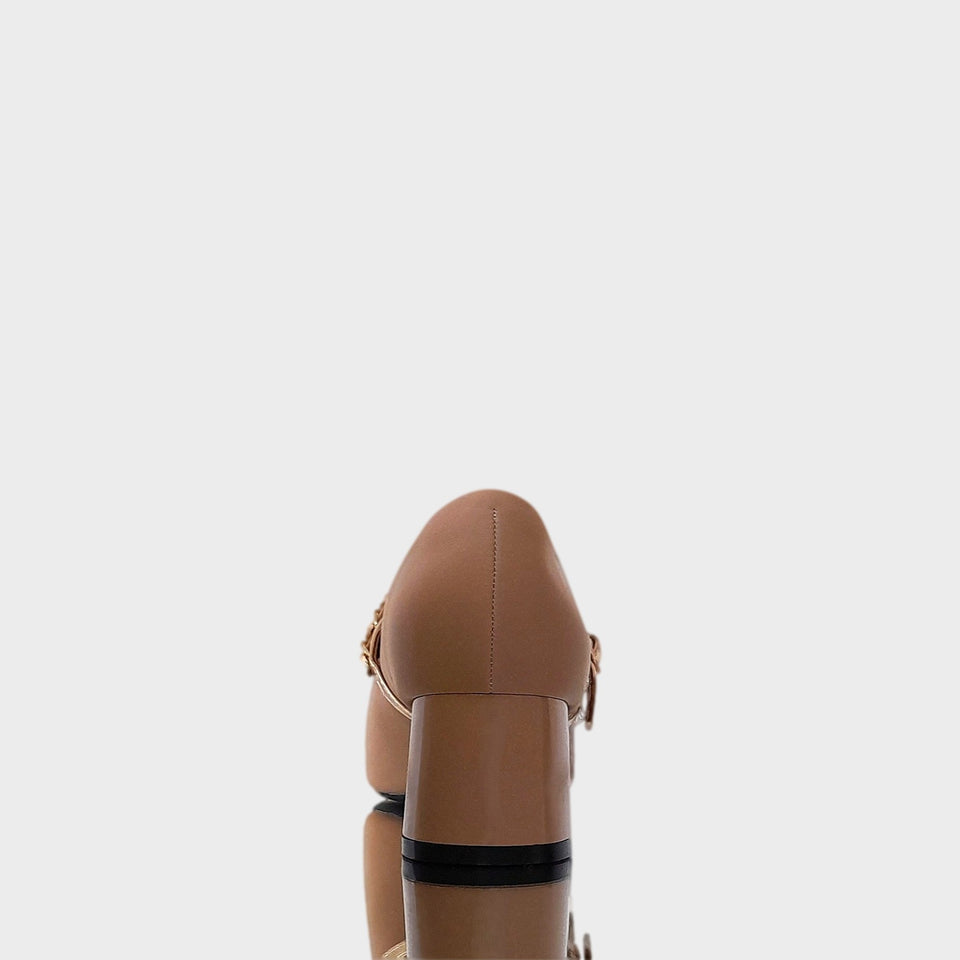 Vista de talón y taco de zapatos Valerie Beige en material satinado e impermeabilizado color beige, con detalle de punta dorada, correa ajustable sobre el empeine y taco bloque acrílico al tono de 5 cm