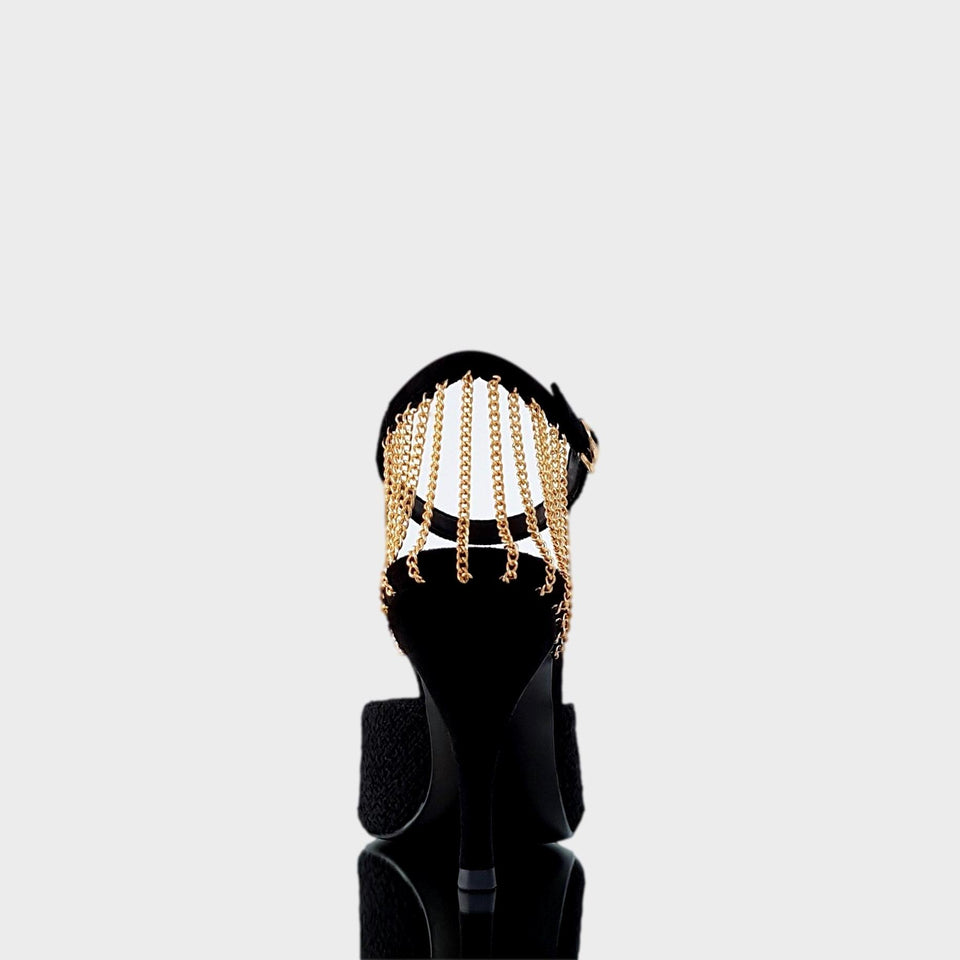 La chica de los stilettos Stilettos Kelly Black en Bouclé Negro, con Detalle de Cadenas de Metal Oro en el Talón, Puntera en Metal Oro, y Taco en Gamuza Negra de 10 cm. Vista de Talón y Taco